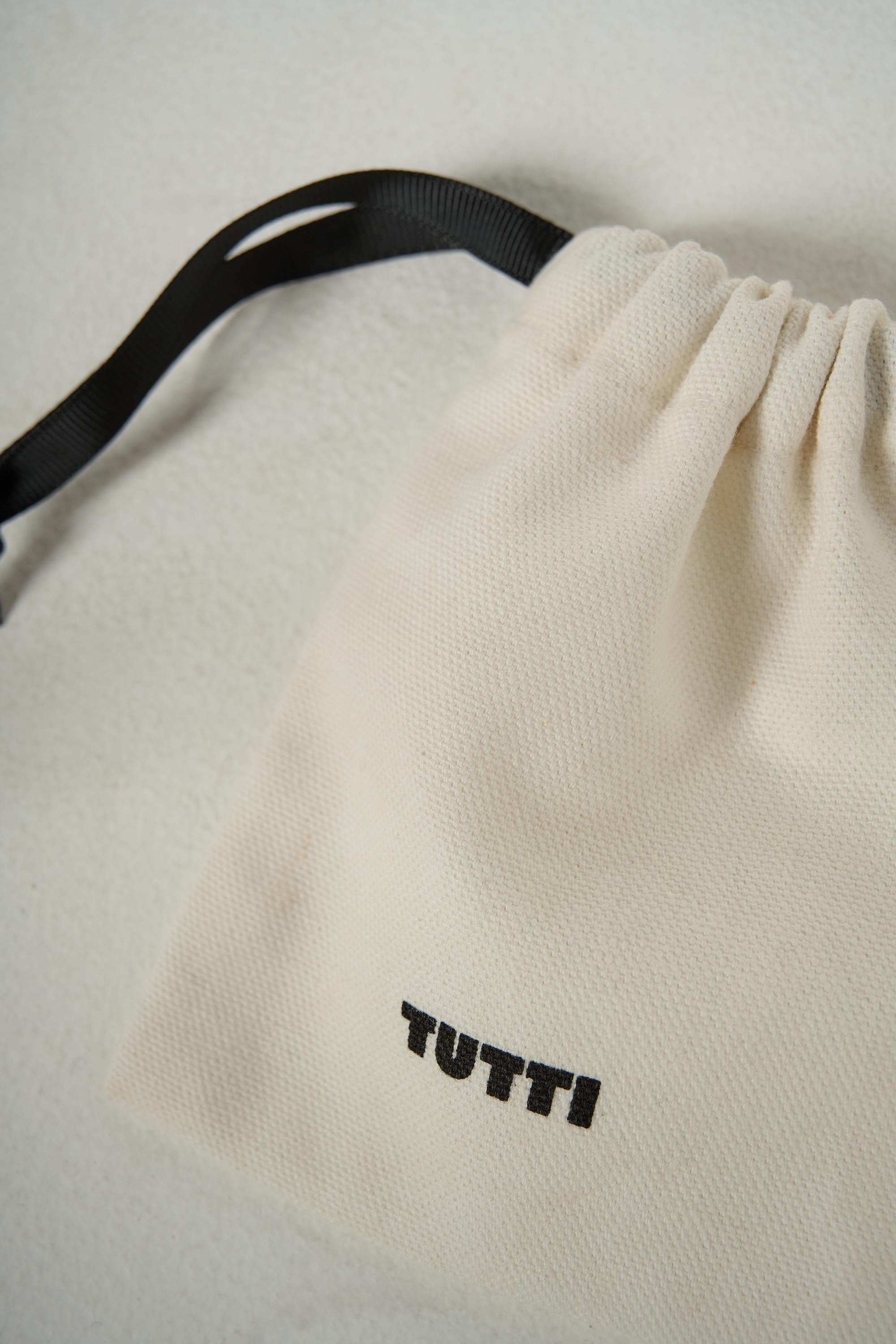 Beige drawstring bag with 'TUTTI' branding on a light gray background
